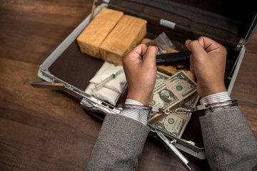 Cocaine, marijuana dollars and handgun on wooden table