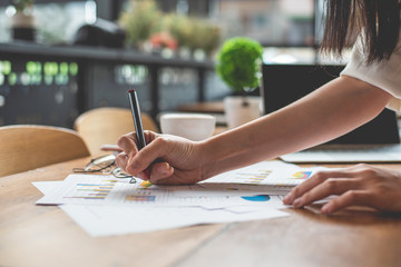 Close up of businesswoman hand writing summary report data. Marketing and business onwership...