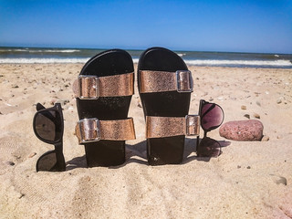 Women's beach accessories on sand for summer vacation concept.