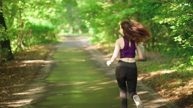 Girl runs through park in the morning