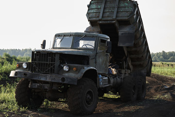 Fototapeta premium Retro dump truck on a quarry with a raised body