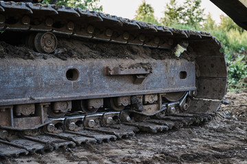 Fototapeta na wymiar dirty tracks of old excavator close up