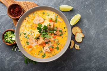 Salmon soup with cream, potatoes, carrots and parsley on gray background. top view. - obrazy, fototapety, plakaty