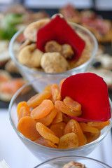 Dried apricot in glass bowl in front of dried figs