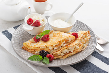 Crepes, thin pancakes with fresh raspberry,blackberry and cottage cheese.