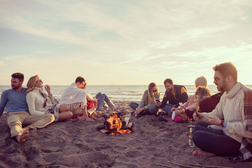 Friends having fun at beach on autumn day