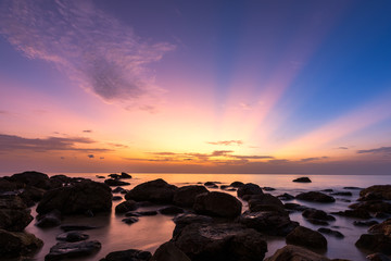 Long exposure of twilight sky with stone beach at sunrise