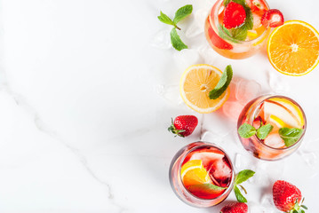 Cold white, pink and red sangria cocktails with fresh fruits, berries and mint.