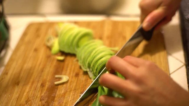 Chopping garlic green in a chopping board at home, Los Angeles