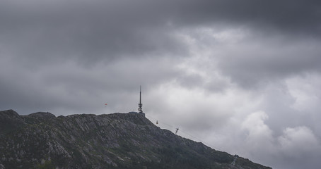 Ulriken in Bergen. Man in parachute in the distance