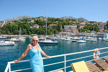 Woman is near yacht handrail on Herceg Novi background, Montenegro.