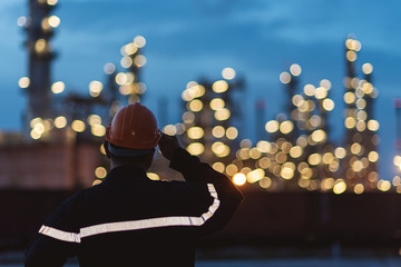 Engineer Wear orange helmet looking for security oil refinery plant