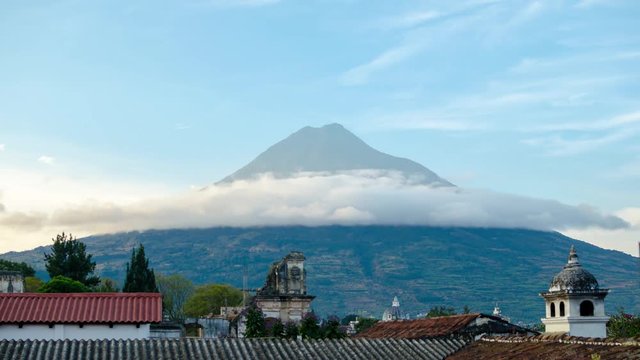Timelapse shot: view to Fuego volcano over rooftops of Antigua town