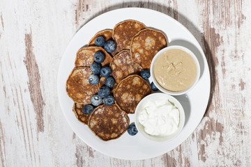 pancakes with peanut butter and yoghurt on white background, top view