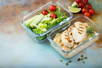 Healthy meal prep containers with quinoa, chicken breast and green salad overhead shot with copy space