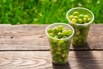 gooseberries in plastic boxes on a wooden table
