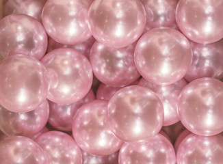 Cutout texture closeup on multiple pink shiny pearls.