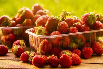 fresh strawberries on a wooden box for sale in plastic boxes, shot close-up