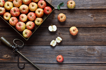 Fresh juicy apples in metal  box and steelyard. Close-up, top view, space for your text on wooden background in vintage stile.