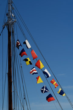 Colorful Nautical Signal Flags Against A Bright Blue Sky