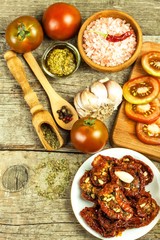 Dried tomatoes pickled in olive oil with garlic. Sunflower seeds with tomatoes on an old wooden table.