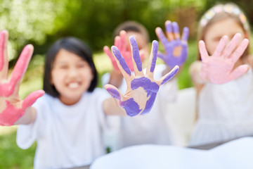 Kinder malen spielerisch mit Fingerfarben