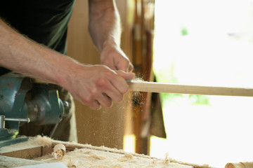 Mann arbeitet mit einer Raspel auf Holzwerkstück in einer Werkstatt