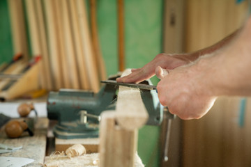 Mann arbeitet mit einer Raspel auf Holzwerkstück in einer Werkstatt