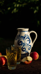 Traditional apple wine in the city of Frankfurt in Hesse. A jug of wine is on an old wooden table...
