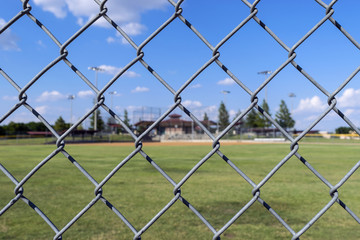 Chain link fence with baseball field background