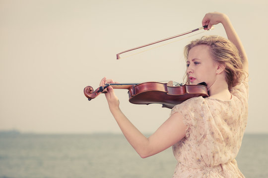 Woman playing violin on violin near beach