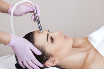 The cosmetologist makes the procedure Microdermabrasion of the facial skin of a beautiful, young...