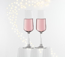 two glasses of pink champagne on glass pyramid