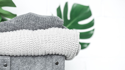 folded clothes with green leaf on white background, place for text