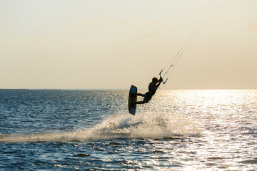 professional kiter doing a complicated trick on a beautiful sunset background