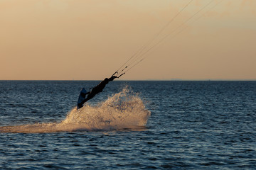 professional kiter doing a complicated trick on a beautiful sunset background