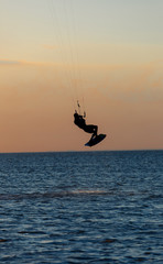 professional kiter doing a complicated trick on a beautiful sunset background
