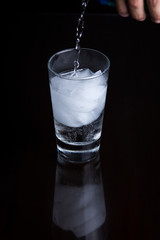 Bubbly drink in a glass on a black background