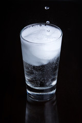 Bubbly drink in a glass on a black background