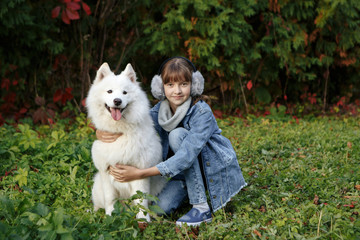 Little girl embracing her dog in a park