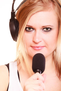 Woman singing to microphone wearing headphones