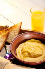 Polenta with butter and some crispy toast. Orange freshly squeezed juice and food on a tray for breakfast in bed. Simple and delicious food for an early morning before work.