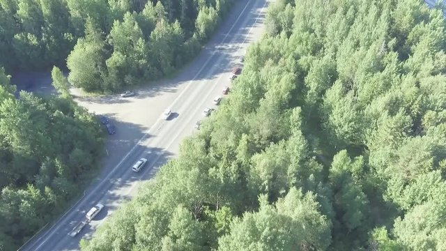 Aerial view of cars traffic on summer forest highway unsaturated