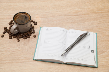 Leerer Kalender auf einem Tisch mit einer Tasse Kaffee
