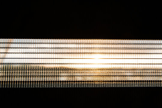 Fototapeta Czarna roleta przebija zachód słońca