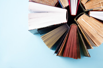 Stack of old books close up on blue background with copy space