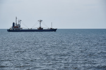 Cargo ship in the sea against the sky.