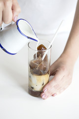 Iced coffee cocktail or frappe with ice cubes and cream