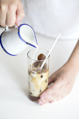 Iced coffee cocktail or frappe with ice cubes and cream