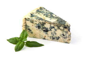 Wedge of soft blue cheese with mold and basil leafs isolated on white background.